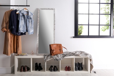 Photo of Modern hallway interior with hanging clothes and shoe rack