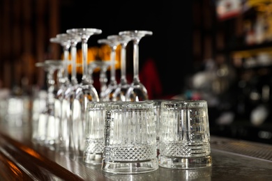 Different empty clean glasses on counter in bar