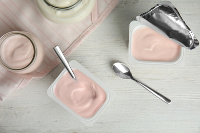 Tasty organic yogurt on white wooden table, flat lay