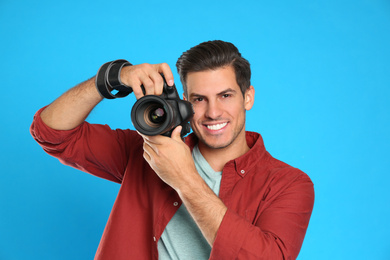 Professional photographer working on light blue background in studio