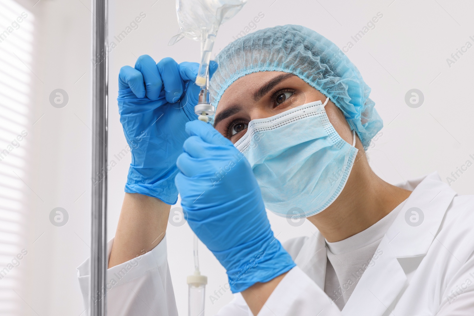 Photo of Nurse setting up IV drip in hospital