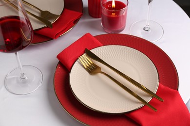 Photo of Place setting with candle for romantic dinner on white table