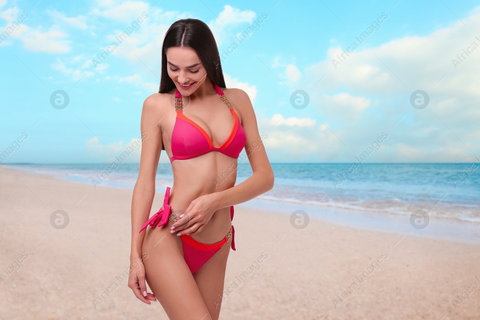 Image of Happy woman in stylish pink bikini on sandy beach near sea, space for text