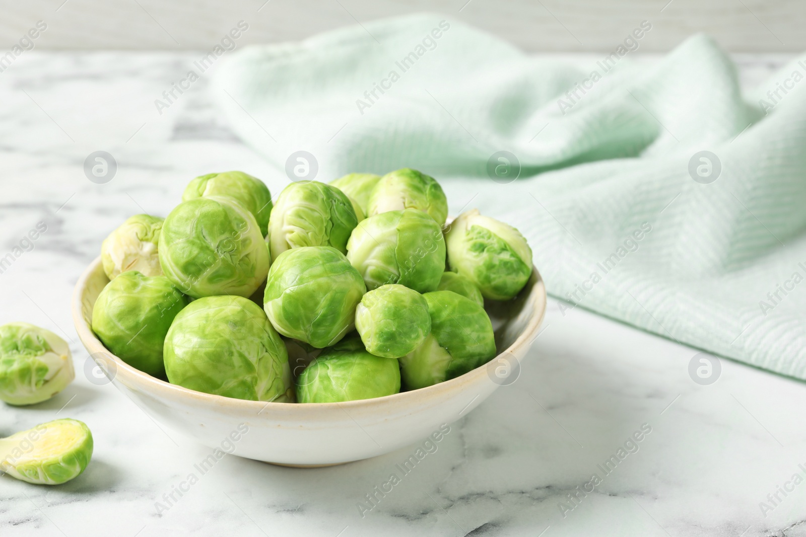 Photo of Bowl with fresh Brussels sprouts on marble table. Space for text