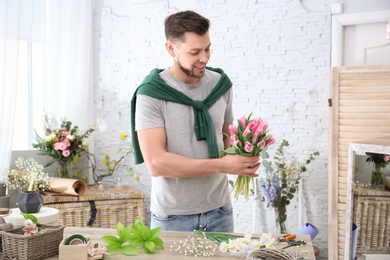 Male decorator creating beautiful bouquet at table