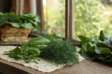 Photo of Different herbs and rusty scissors on wooden windowsill indoors, space for text