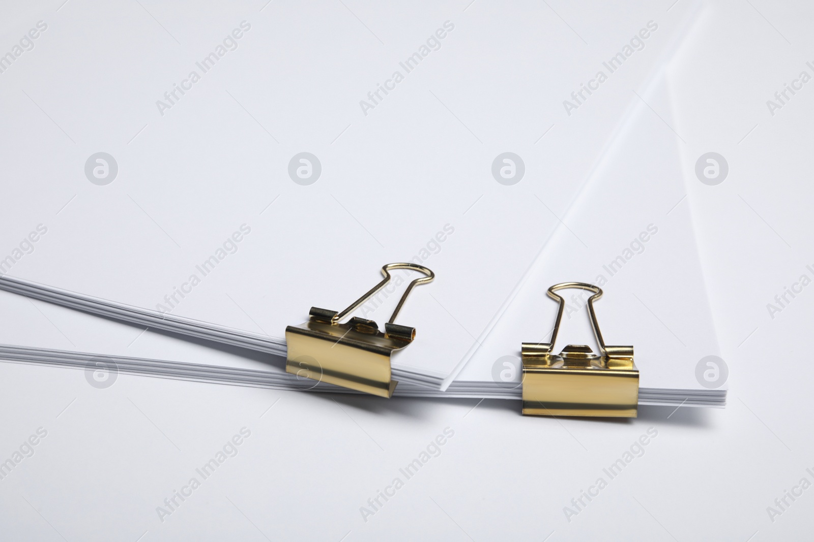 Photo of Sheets of paper with clips on white background, closeup