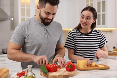 Lovely young couple cooking together in kitchen