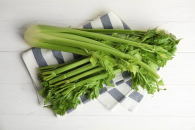 Photo of Fresh ripe green celery on white wooden table, flat lay