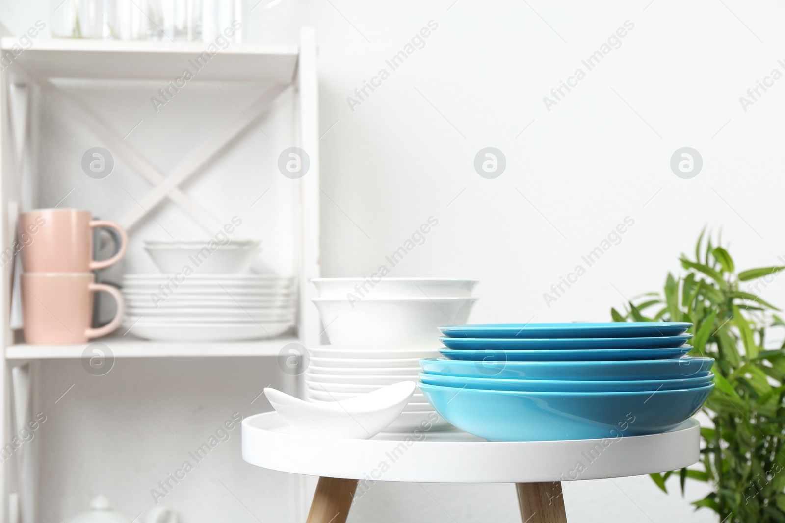 Photo of Different clean tableware on small table in kitchen