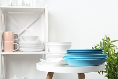 Different clean tableware on small table in kitchen