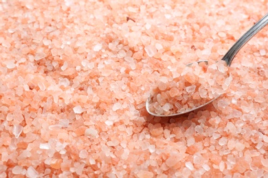 Pink himalayan salt and metal spoon as background, closeup