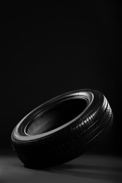 Photo of New car tire on black background