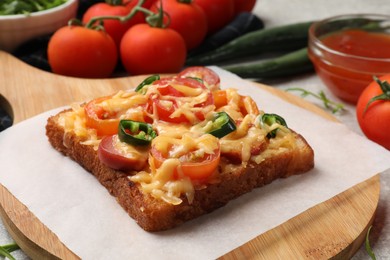 Tasty pizza toast and tomatoes on table, closeup