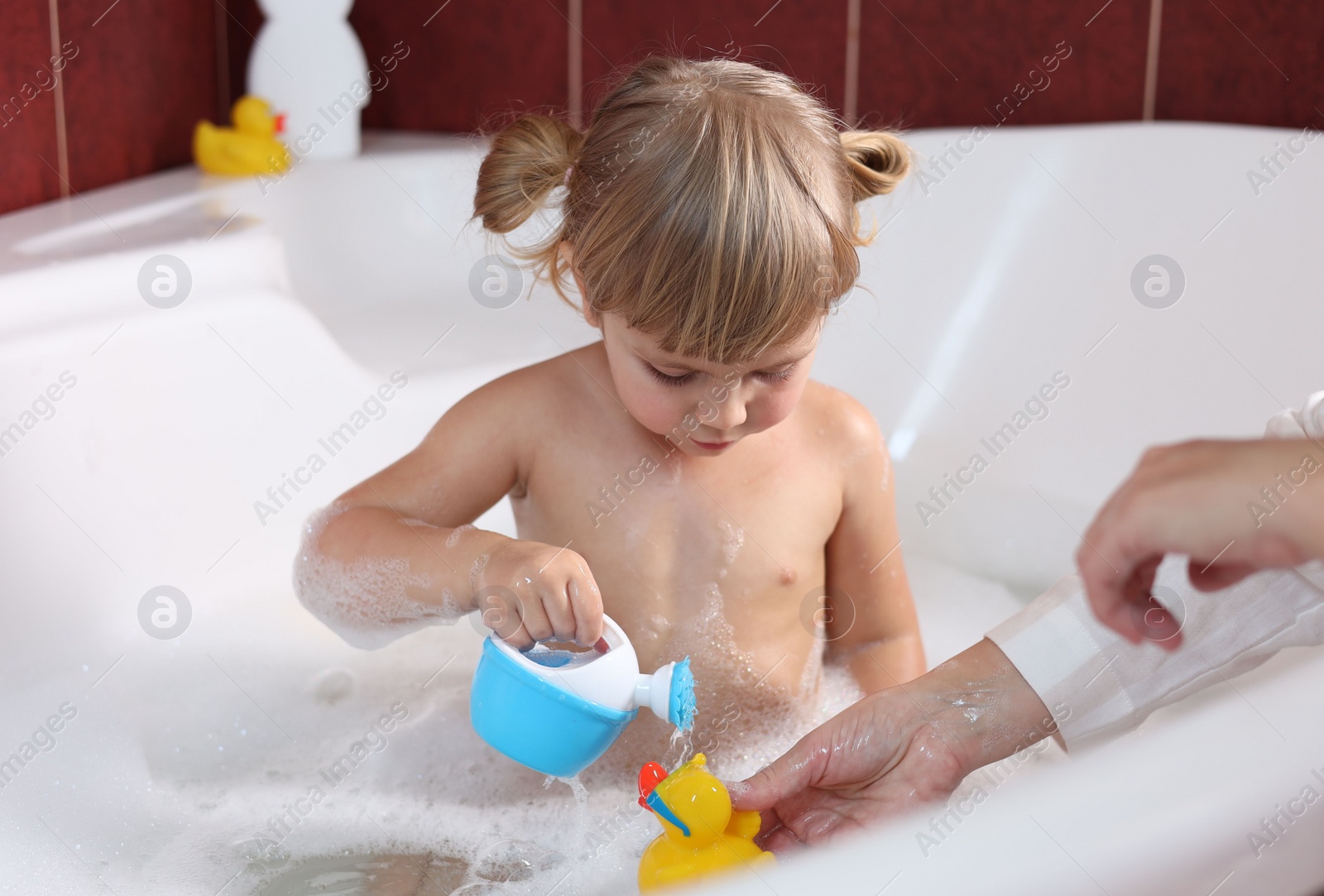 Photo of Mother playing with her little daughter in bathroom, closeup