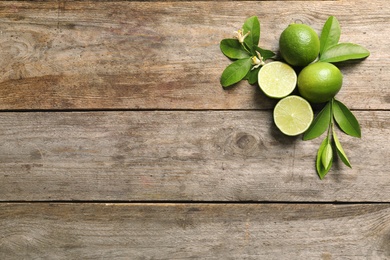 Photo of Composition with fresh ripe limes on wooden background, top view