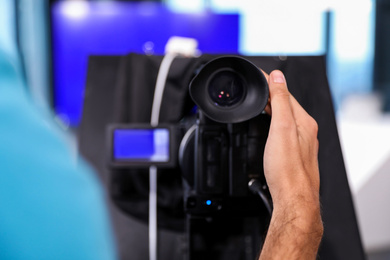 Professional video camera operator working in studio, closeup