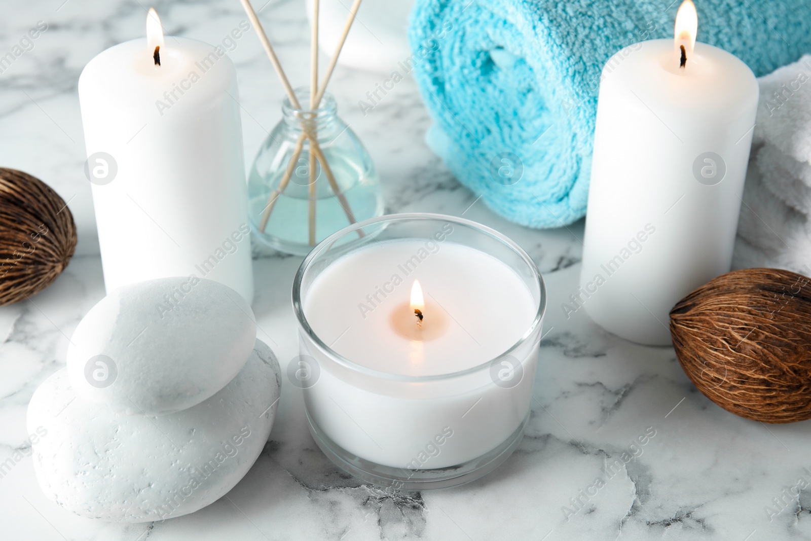 Photo of Beautiful spa composition with candles and stones on marble background