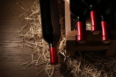 Photo of Composition with crate and bottles of wine on wooden table