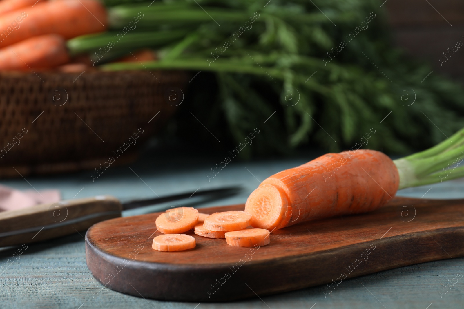 Photo of Fresh raw cut carrot on blue wooden table