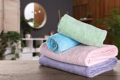 Fresh towels on wooden table in bathroom