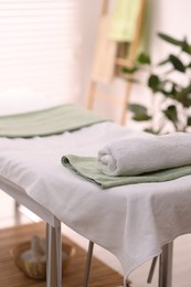 Rolled towel on massage table in spa center