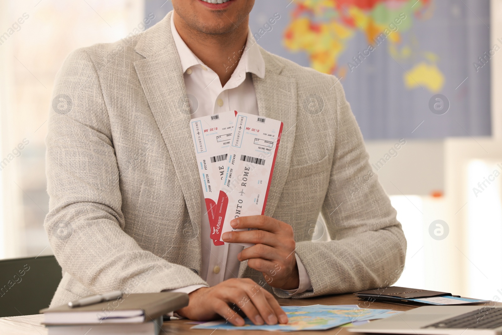 Photo of Travel agent with tickets at table in office, closeup