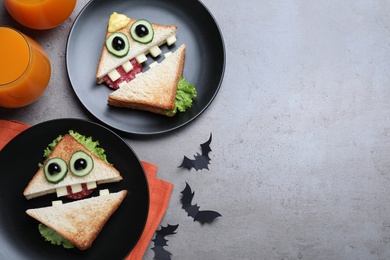 Photo of Cute monster sandwiches served on grey table, flat lay with space for text. Halloween party food