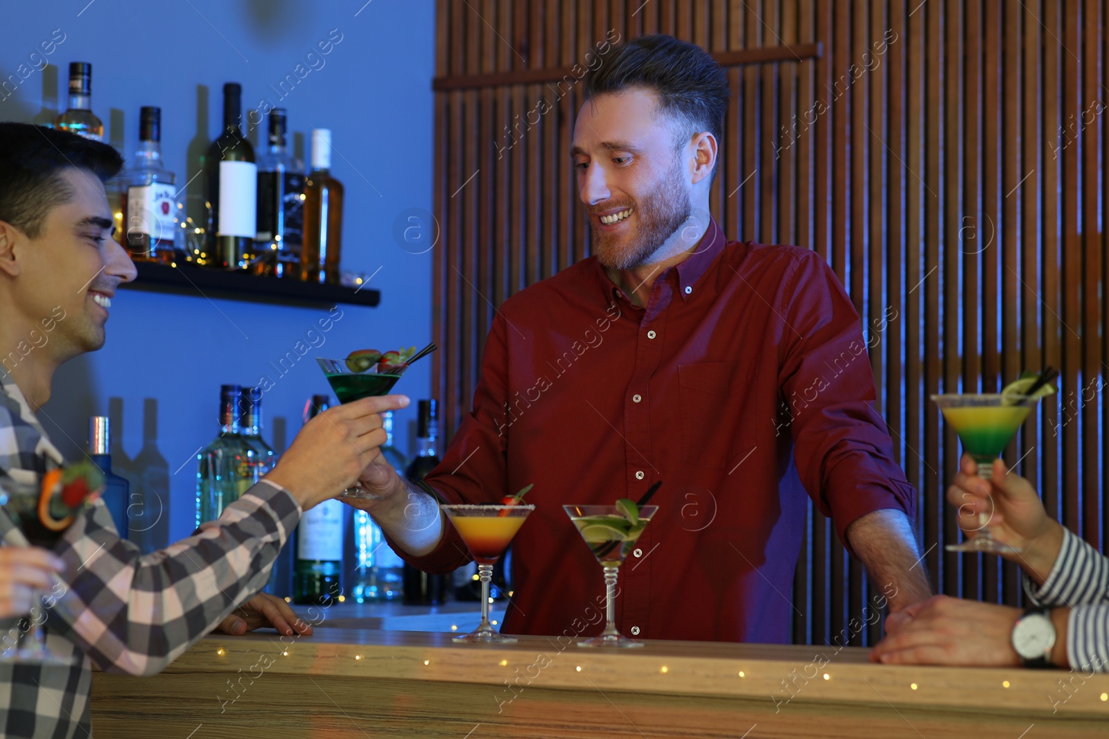 Photo of Young man taking martini cocktail from barman at party