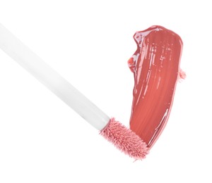 Photo of Stroke of color lip gloss and applicator isolated on white, top view