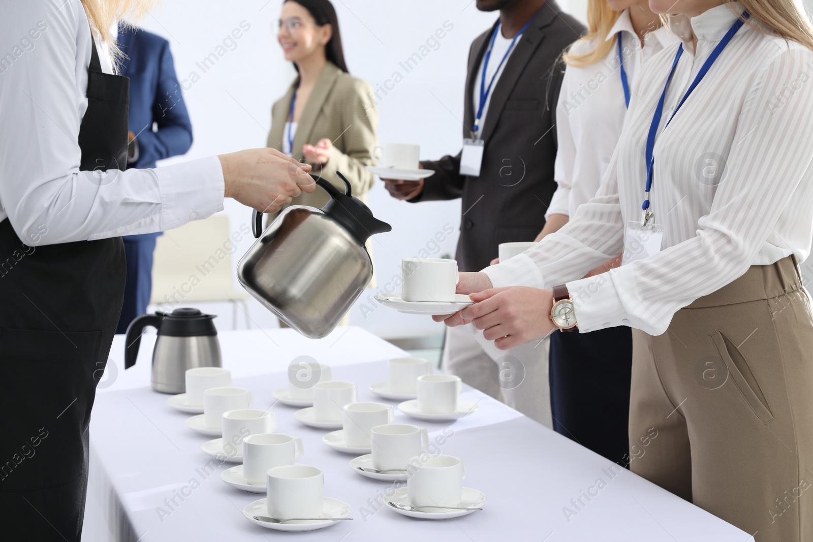 Photo of Waitress pouring hot drink during coffee break, closeup