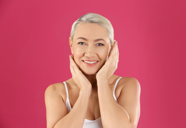 Photo of Portrait of beautiful mature woman on pink background