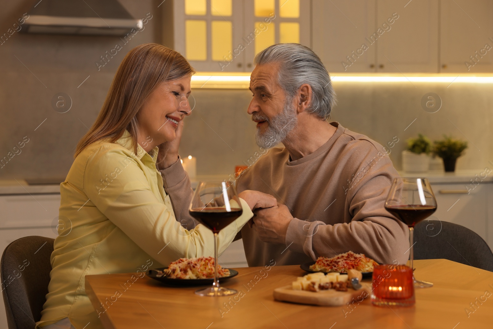 Photo of Affectionate senior couple having romantic dinner at home