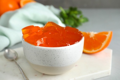 Composition with orange jelly in bowl on table