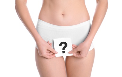 Photo of Young woman holding paper with question mark near underwear on white background. Gynecology