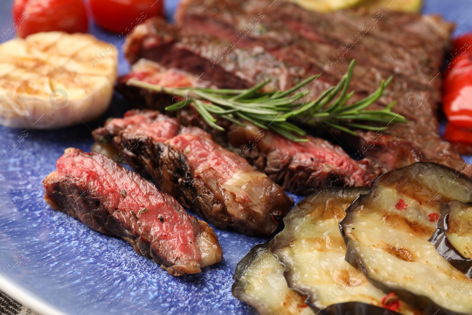 Photo of Delicious grilled beef with vegetables and rosemary on plate, closeup