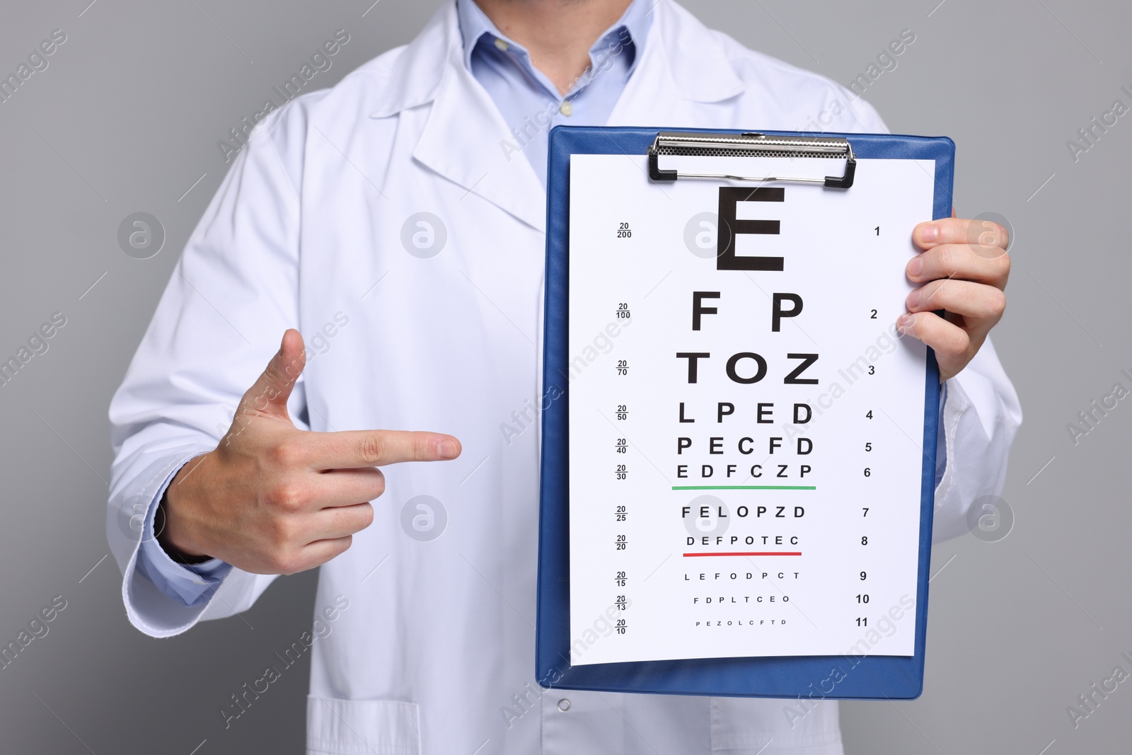 Photo of Ophthalmologist pointing at vision test chart on gray background, closeup