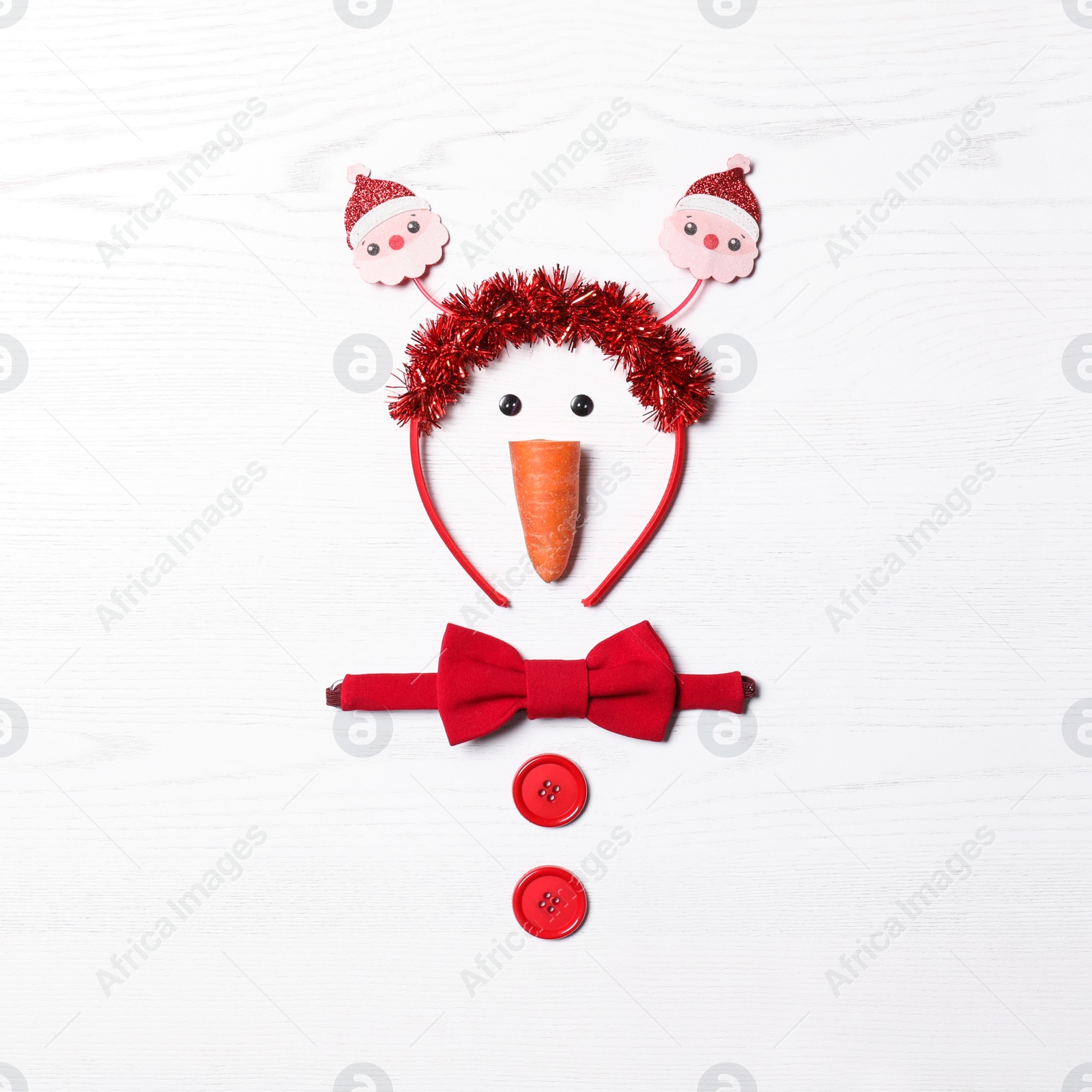 Photo of Funny snowman made with different elements on white wooden background, flat lay