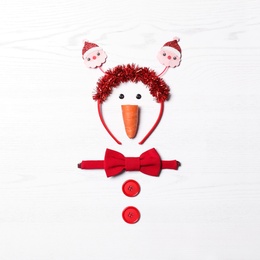 Funny snowman made with different elements on white wooden background, flat lay