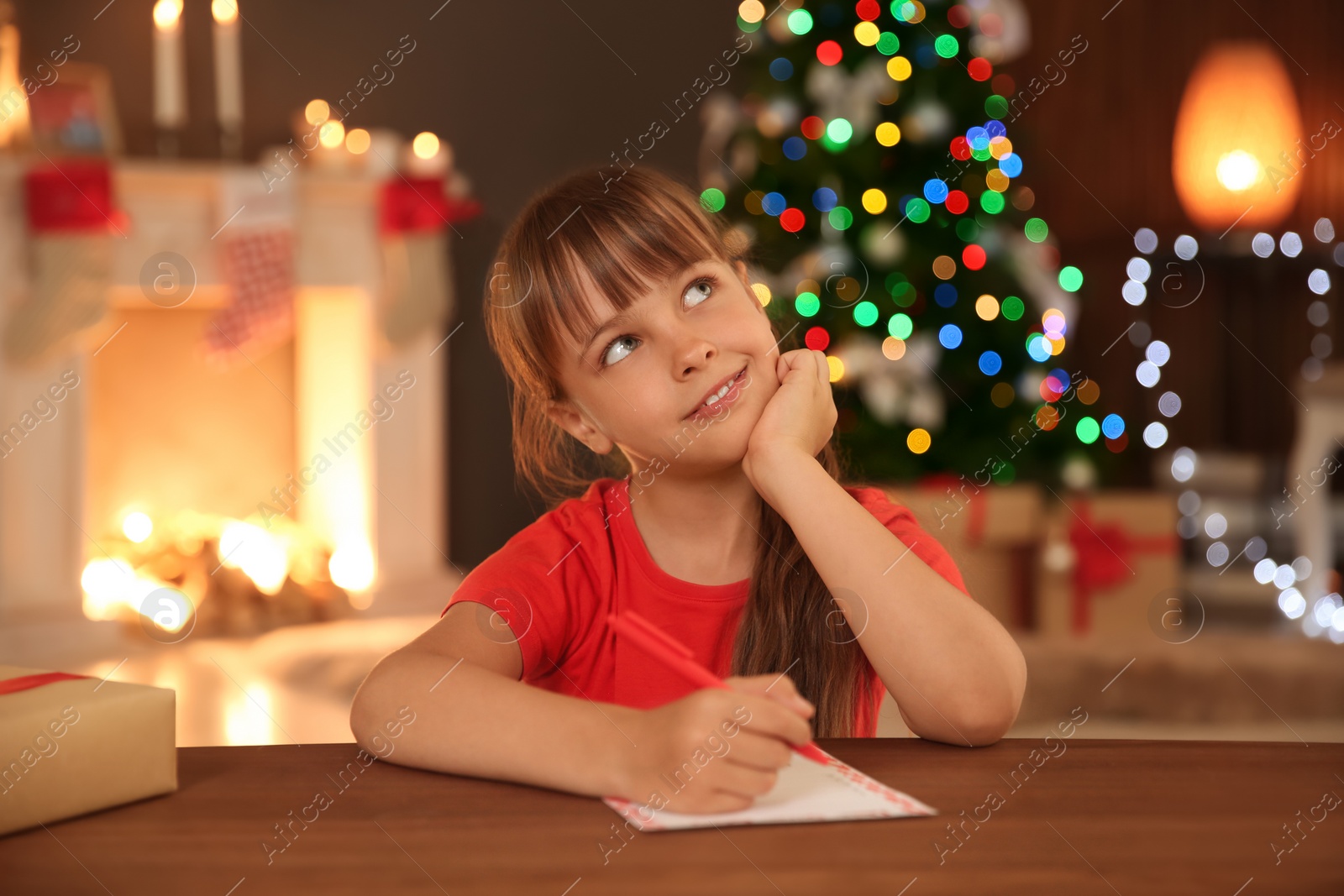 Photo of Little child writing letter to Santa at home. Christmas celebration