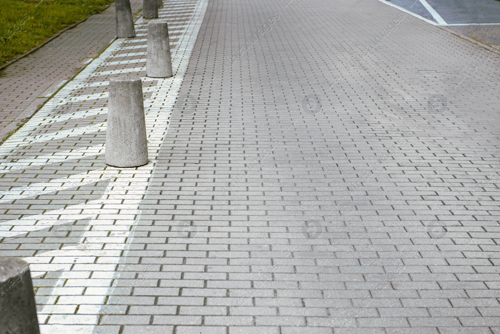 Photo of View on grey stone sidewalk. Footpath covering