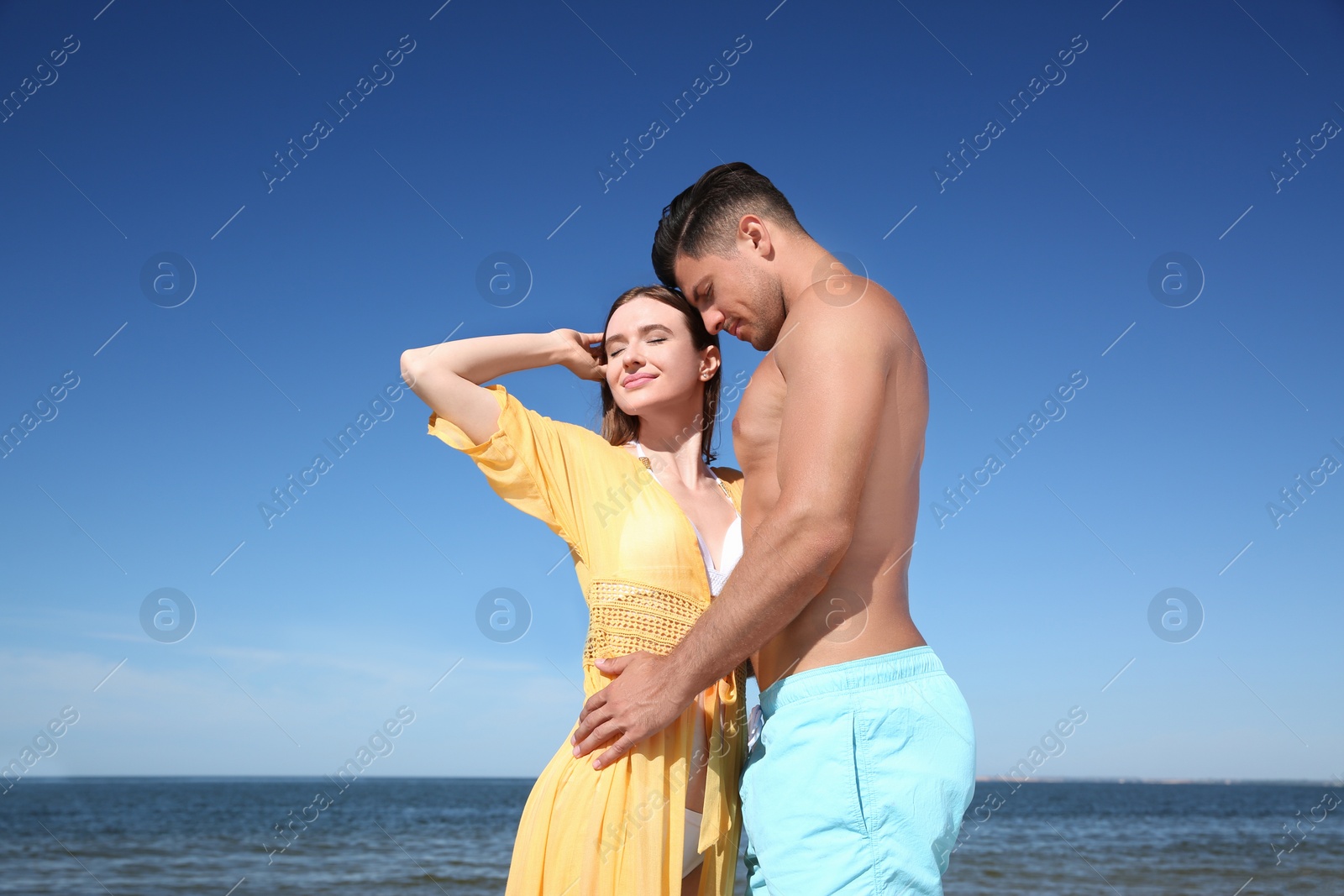 Photo of Beautiful woman and her boyfriend on beach. Happy couple