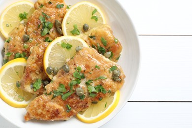 Delicious chicken piccata on white wooden table, top view