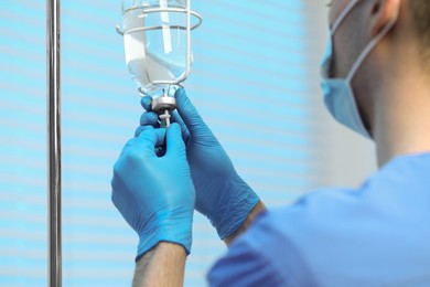 Photo of Nurse setting up IV drip in hospital, closeup