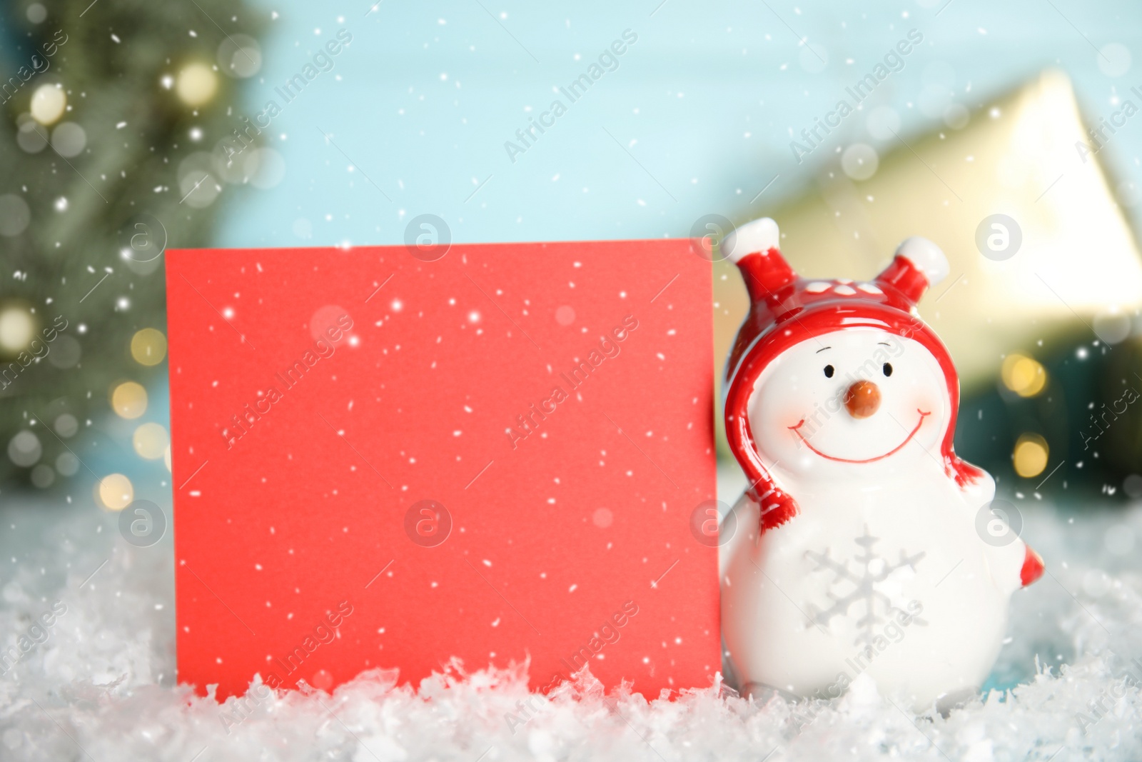 Photo of Funny decorative snowman and blank red card on table