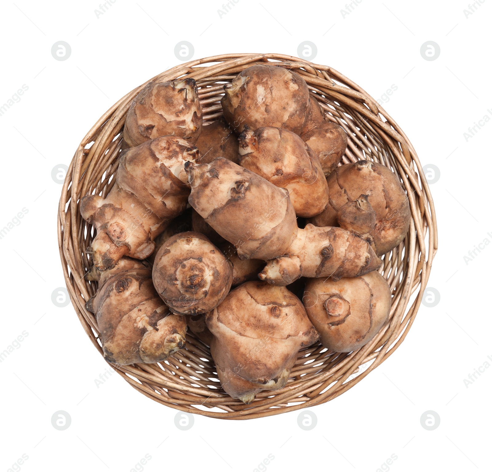 Photo of Wicker basket with many Jerusalem artichokes isolated on white, top view