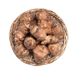 Photo of Wicker basket with many Jerusalem artichokes isolated on white, top view