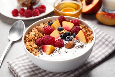 Tasty homemade granola with yogurt served on grey table. Healthy breakfast
