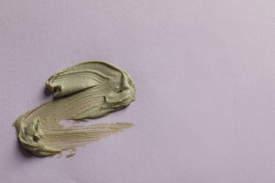 Photo of Sample of face cream on lilac background, top view. Space for text