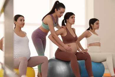 Photo of Trainer working with group of pregnant women in gym. Preparation for child birth